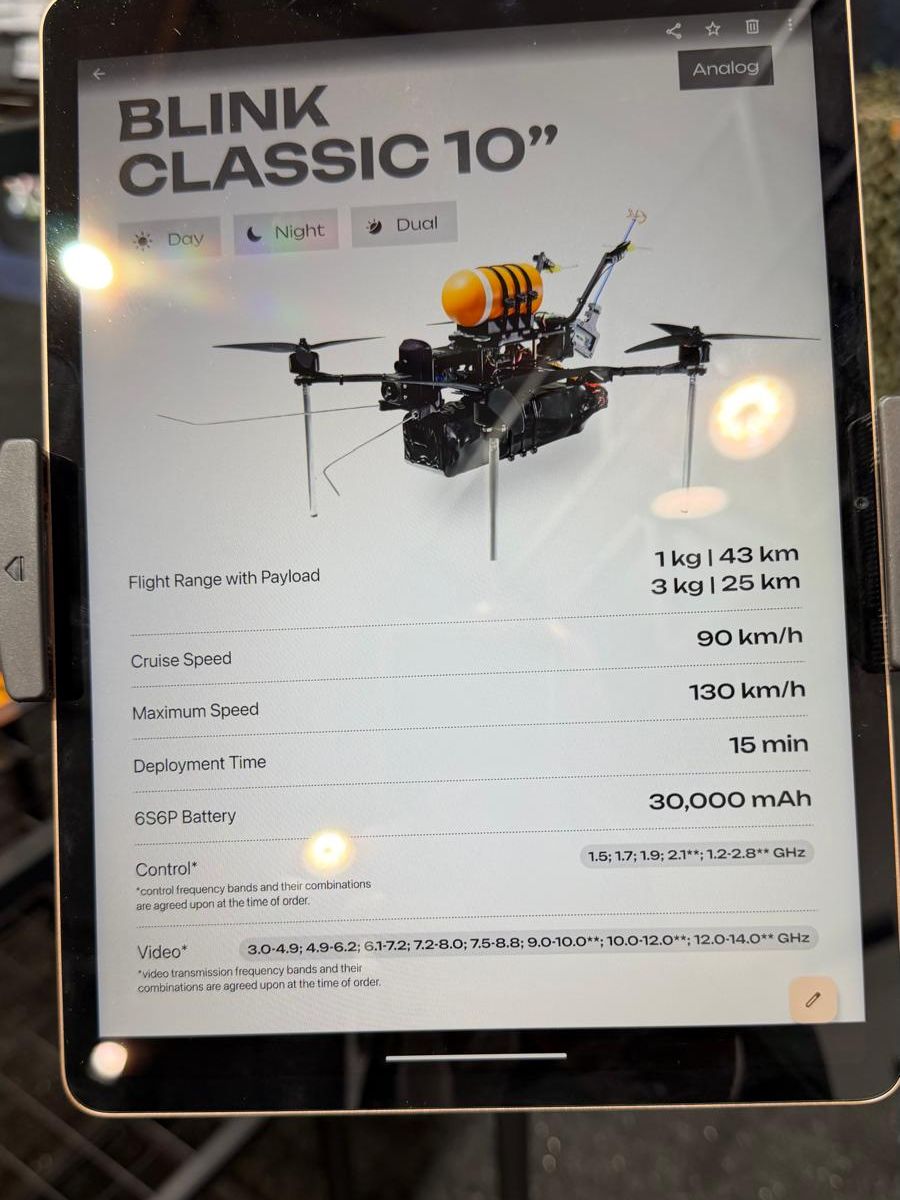 Tablet showing specifications of a 10-inch FPV drone: 1 kg over 43 km, 3 kg over 25 km, 90 km/h cruise, 130 km/h maximum