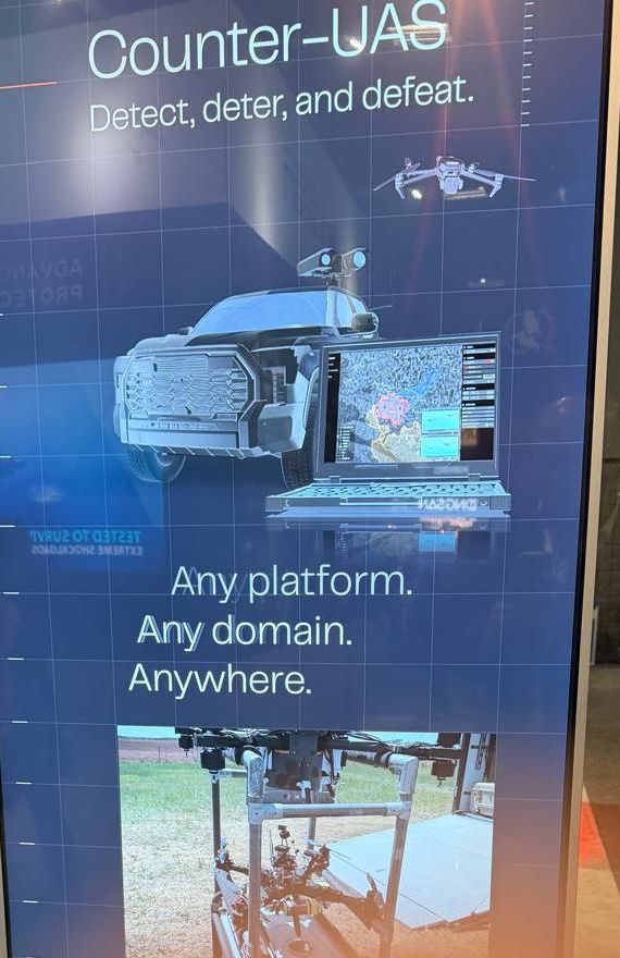 Vertical display reading Counter-UAS, detect, deter, and defeat, any platform, any domain, anywhere, with a vehicle and laptop graphic