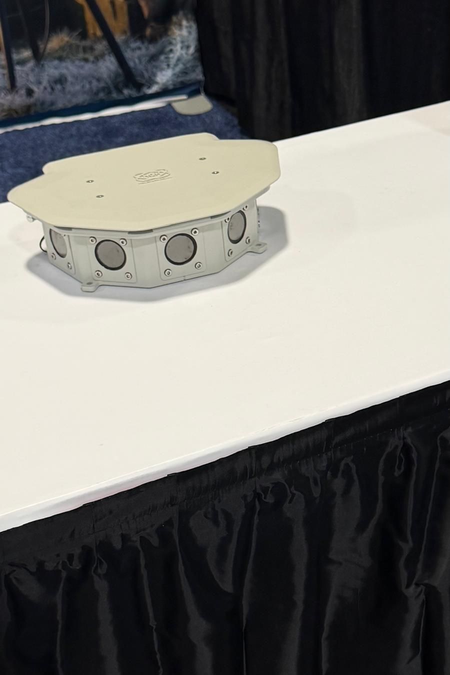 HGH Spynel-F staring thermal unit, a flat grey housing with several lenses, on a white table